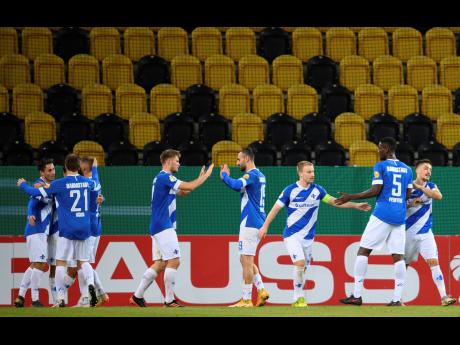 Darmstadt’s players cheer after scoring their second goal against Dynamo Dresden during their German Bundesliga second-round match played in an empty stadium, despite more than 72,000 tickets being sold for the game at the Rudolf-Harbig-Stadion in Dresde