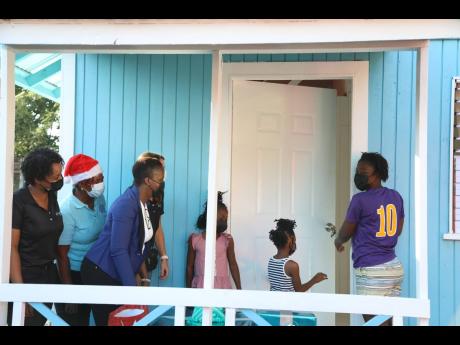 Sharon Roache and her daughters were overjoyed and relieved to open the door to her new home that was built by Active Home Centre and Food For The Poor. Looking on (from left) are Susan Melbourne Townsend, marketing manager, Active Home Centre; Kivette Sil