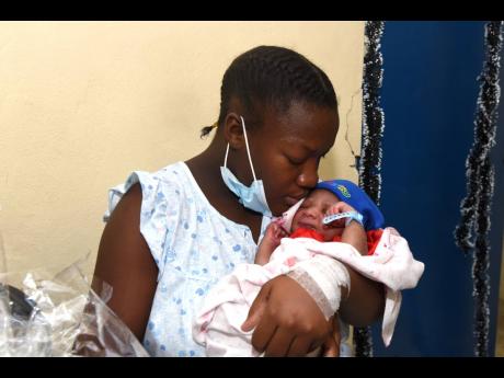 First-time mom Naketa Dockery cradles her newborn Leondre Gray. Leondre was born at 3:34 a.m. on Christmas Day at the Victoria Jubilee Hospital, weighing 3.48kg. The mother received a basket and other supplies from the Kiwanis Club in collaboration with An
