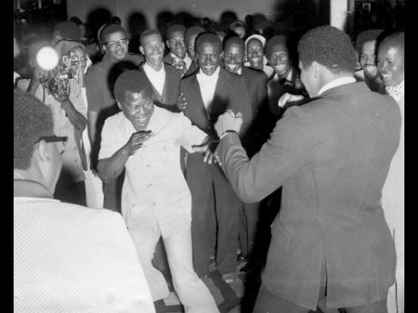 Bunny Grant (left) is all smiles as he spars with Muhammad Ali at the reception given by National Sports Limited at the Jamaica Pegasus Hotel on December 28.