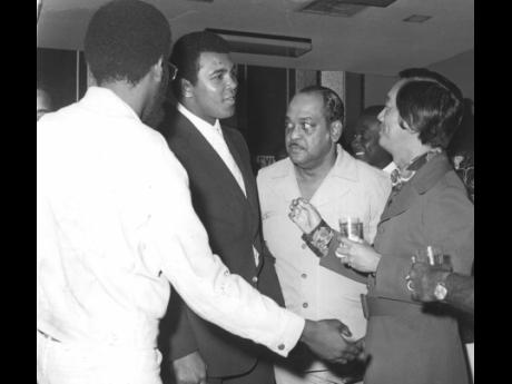 Muhammad Ali (second from left) is all ears as Jamaica’s number one boxing promoter and entrepreneur Lucien Chen (right) makes a point after National Sports Public Relations,  Officer Raymond Sharpe (extreme left) had introduced the local sports personal