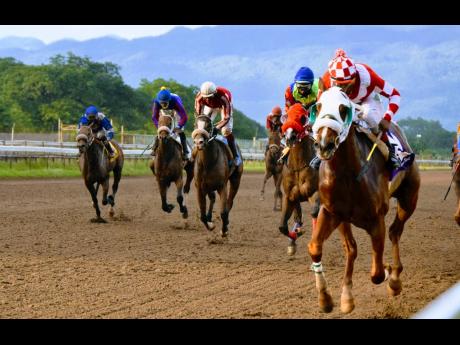 FURTHER AND BEYOND (right), ridden by Ian Spence, wins the Two-Year-Old Stakes at Caymanas Park  yesterday.