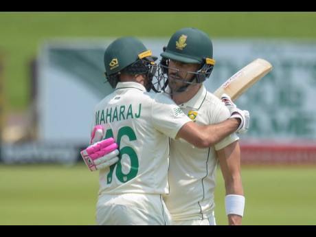 South Africa’s Faf du Plessis (right) reaches 150 and is embraced by teammate Keshav Maharaj, on day three of the first cricket Test match between South Africa and Sri Lanka at Super Sport Park Stadium in Pretoria, South Africa, on Monday, December 28, 2