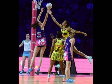 Jamaica goal keeper Shamera Sterling (second right) goes high to defend ahead of Scotland goal shooter Emma Barrie (left), while Jamaica’s Adean Thomas (second left) and Scotland’s Lynsey Gallagher  look on during their Vitaly Netball World Cup Group G