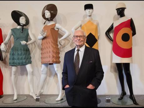 French fashion designer Pierre Cardin poses with dresses behind during the inauguration of the Pierre Cardin Museum in Paris.
