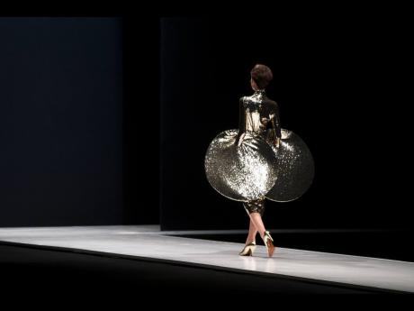 In this March 22, 2016 file photo, a model displays a creation by French fashion designer Pierre Cardin during Moscow Fashion Week, Russia. 