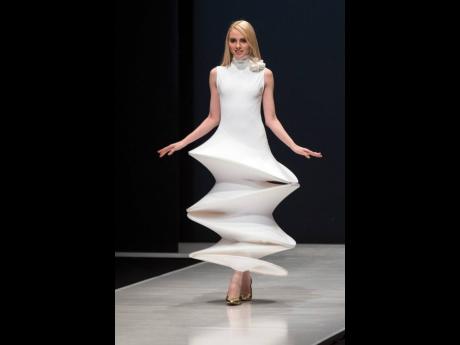 In this March 2016 file photo, a model displays a creation by French fashion designer Pierre Cardin during Moscow Fashion Week, Russia. 