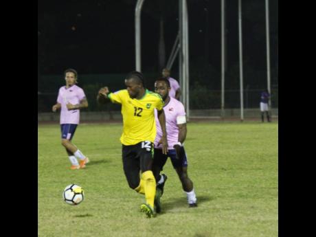 Jamaica forward Kemar Beckford (front) chases after the ball while being harried by Bermuda player Cecoy Robinson during their international friendly match at the Montego Bay Sports Complex on Wednesday, March 11, 2020.