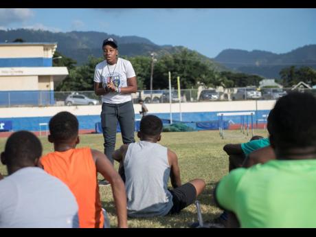 Coach Monique Morrison (standing) speaks to members of the Jamaica College lacrosse team during a training session at Jamaica College Ashenheim Stadium on Thursday, January 16, 2020.
