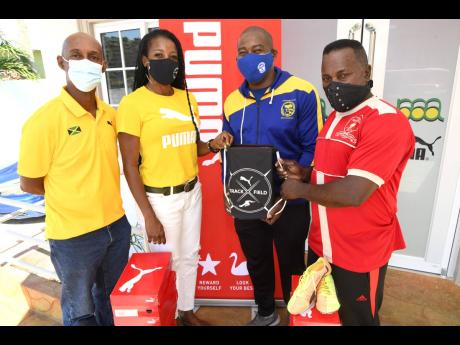 Juliet Campbell (second left), manager, sports marketing central at Puma, makes a presentation of running gear to Samuel Brevette (right), assistant coach of Mona High, and Gary Mendez (second right), vice- president of Jose Marti Technical High Past Stude