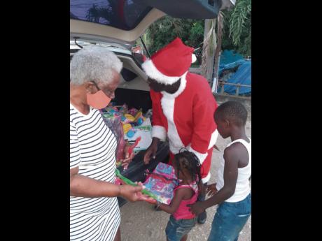  Myrtle Roye, justice of the peace, and Otis James distribute toys to children in Effortville, Clarendon.