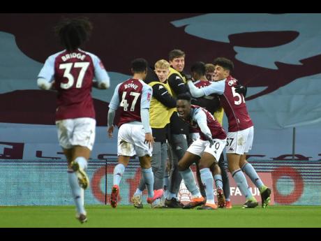 Aston Villa’s players celebrate an equalising goal scored by Louie Barry during their FA Cup third round match against Liverpool at Villa Park in Birmingham, England, yesterday.