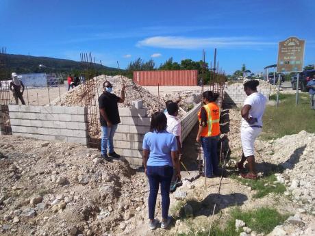 Members of St James Municipal Corporation’s team, along with representatives from the National Environment and Planning Agency and residents of Greenwood, at one of the building sites in the St James community where a stop order was served last Friday.