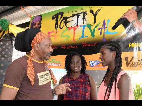 Yasus Afari (left) sharing some poetry tips with poet enthusiasts, Natalia Reid (centre) and Rushana Richards, during a poetry workshop at the Ranny Williams Entertainment Centre.