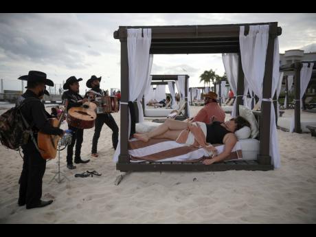 Roving musicians Los Compas serenade a couple on the shore of Mamitas beach in Playa del Carmen, Quintana Roo state, Mexico, on January 5.