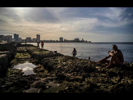 People sunbathing at sunset on the Malecon in Havana, Cuba, on Friday, January 1. 
