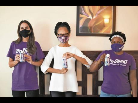 From left: Lauren Mahfood, marketing manager of Trade Winds Citrus; Arlene Martin, acting general manager of Professional Football Jamaica; and Keresha Ferguson, marketing coordinator, Trade Winds Citrus, pose with bottles of Tru Shake after Trade Winds Ci