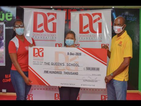Dennis Beckford presents the principal of The Queen’s School, Jennifer Williams (centre), and her Dean of Discipline Helen Powell with a cheque for half million dollars following the school’s victory in the Desnoes and Geddes (D&G) Foundation 5 for 5 p