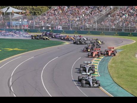 In this March 17, 2019, photo, Mercedes driver Valtteri Bottas (bottom), leads his teammate Lewis Hamilton and the rest of the pack during the start of the Australian Formula 1 Grand Prix in Melbourne, Australia. The start of the 2021 Formula One season ha