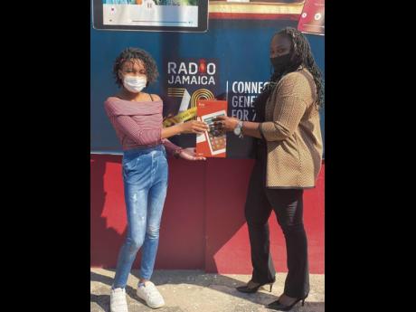 Jonacee Graham (right), producer of  Radio Jamaica’s afternoon programme ‘Too Live Crew’, presents Jade Bloomfield with her prize. 