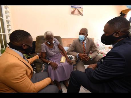Doris Walker speaking with (from left) Pastor Dexter Dennis, St Catherine South Eastern Member of Parliament Robert Miller and Pastor Coniel Morgan during her 102nd birthday celebration.