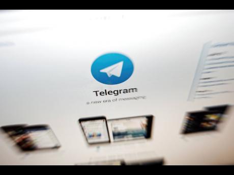 left: The website of the Telegram messaging app is seen on a computer screen.