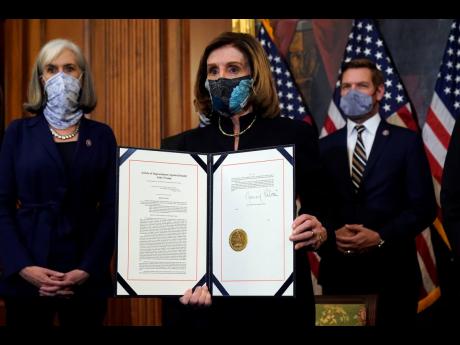 House Speaker Nancy Pelosi displays the signed article of impeachment against President Donald Trump in an engrossment ceremony before transmission to the Senate for trial on Capitol Hill in Washington on Wednesday.