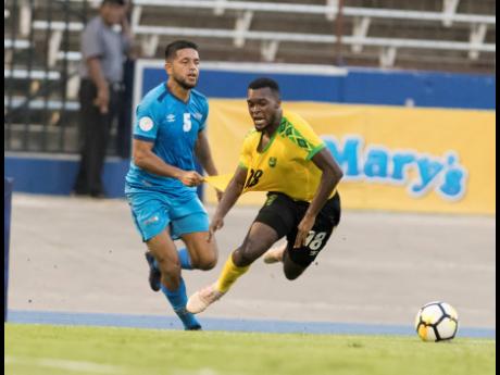 Jamaica’s Brian Brown (right) is taken down by Aruba’s Noah Harms in their Concacaf Nations League match at the National Stadium in Kingston on Saturday, October 12, 2019.
