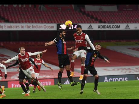 Arsenal’s Pierre-Emerick Aubameyang (centre) jumps for the ball during their English Premier League match against Crystal Palace at Emirates Stadium in London, England, yesterday.