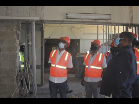 Opposition Spokesman on Health Dr Morais Guy (centre) is shown a section of the ongoing construction work at the Cornwall Regional Hospital by Errol Greene (right), regional director of the Western Regional Health Authority, during a tour of the facility b