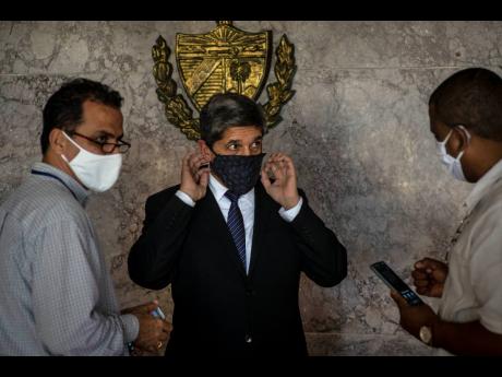 Cuba’s Director General of US Affairs Carlos Fernández de Cossio (centre) puts on a mask as a precaution against the spread of the new coronavirus, after a press conference in Havana, Cuba, on January 12, 2021. The Trump administration has re-designated