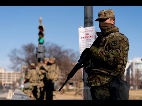 Armed members of the National Guard stand guard outside the US Capitol on Capitol Hill in Washington, Thursday, January 14, 2021.