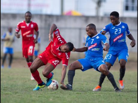 

Emelio Rousseau (right) looks on as teammate Damion Williams (centre) of Portmore United FC successful tackles UWI FC’s Patrick Brown (left) in a Premier league football match played at the Mona Bowl on Sunday March 3, 2019.