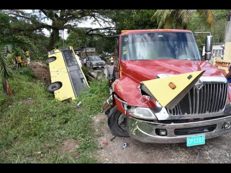 Wreckage from a Jamaica Urban Transit Company bus remains jammed into the bonnet of a parked wrecker in Temple Hall, St Andrew, after the driver reportedly lost control on Thursday. The bus ended up in a ditch. 
