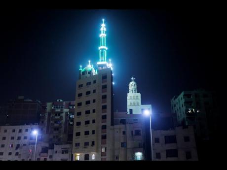 A general view of a Coptic church and the minaret of mosque on top of a residential building, on Coptic Christmas eve in Cairo, Egypt, Wednesday, January 6, 2021. Egypt’s Coptic Orthodox Christians have been barred from attending Mass on Christmas Eve at