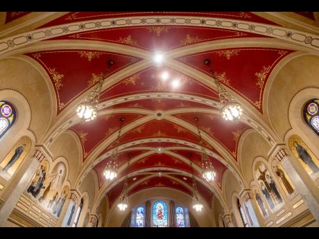 
The ceiling of the sanctuary at Sacred Heart Catholic Church is painted red with gold detail work along the edges in Peoria.