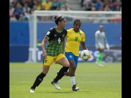 Jamaicas Chantelle Swaby (left) is challenged by Brazil’s Formiga Maciel Mota during their FIFA Women’s World Cup match at Stade des Alpes in Grenoble, France, on Sunday, June 9, 2019.