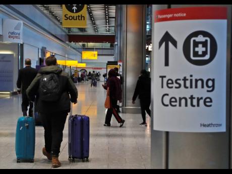 Travellers walk towards the COVID-19 testing centre at Heathrow Airport in London on, Sunday. The UK closed all travel corridors from January 18 to protect against the coronavirus, with travellers entering the country from overseas required to have proof o