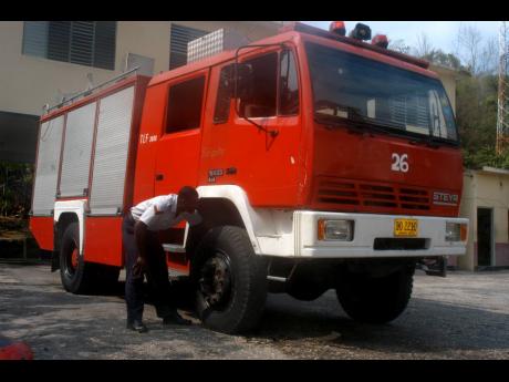 In this 2005 file photo Lance Corporal Demetri Rankine inspects a fire tuck at the Lucea Fire Station, in Hanover 
