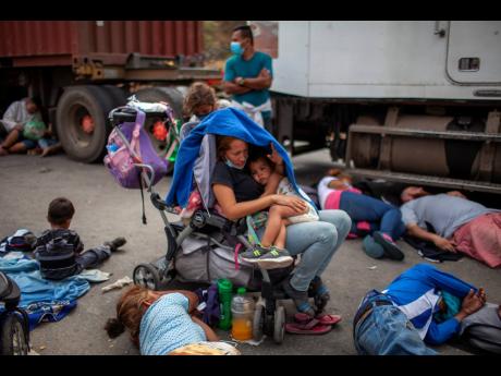 Honduran migrants gather in front of a police roadblock at a highway in Vado Hondo, Guatemala, on Sunday. 