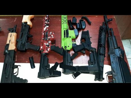 Guns and ammunition were discovered in a fridge at a Montego Bay wharf on Monday, January 18. This photo shows assault rifles that were among 19 illegal guns found at another wharf in MoBay last week. 