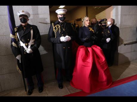 Flanked by Marine escort Captain Evan Campbell, Lady Gaga arrived to sing the national anthem in a custom ensemble by Texan designer Daniel Roseberry for the French design house Schiaparelli. 