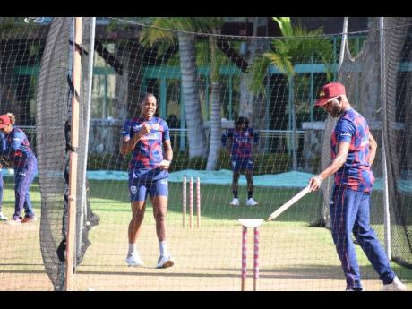 West Indies Women’s assistant coach Corey Colleymore (right) goes through bowling drills with Jamaican player Chinelle Henry in the current camp at the Collidge Cricket Ground in Antigua.