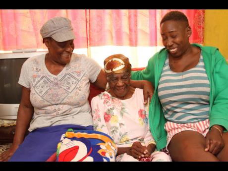 Centenarian Roslyn Stephens of Spaldings, Clarendon, shares a light moment with her daughter-in-law Yvonne Knight (left) and her caregiver and granddaughter Tracy Stephens (right). Roslyn, who was a farmer and minister of the gospel, is giving God thanks f
