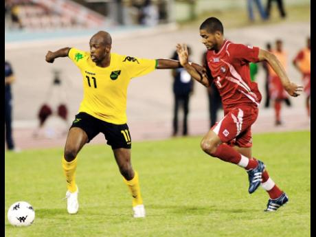 Shelton (left) holds off a Panama opponent during a friendly international football match at the National Stadium in Kingston in June 2009.