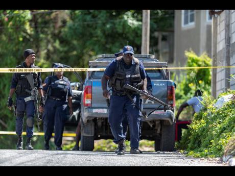 Police officers at a crime scene in Goldsmith Villa, located in August Town, St Andrew, where one person was shot dead and another two injured in 2019.