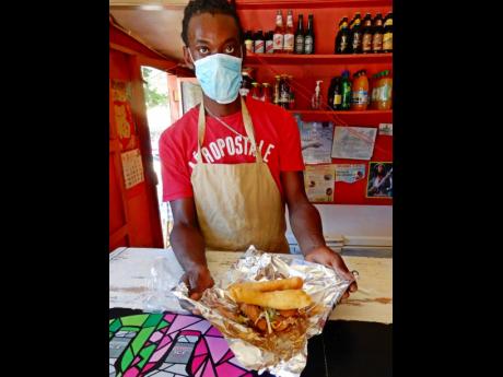 Thomas, at Merl’s Fish Joint, serves up a Jamaican favourite, fish and festival. 