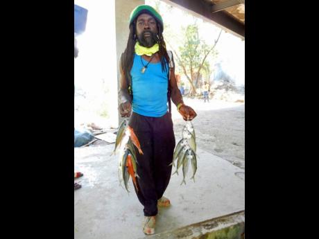 A fisherman with two strings of fish.