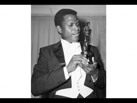 Actor Sidney Poitier appears with his Oscar for Best Actor, for his role in ‘Lillies of the Field’, at the 36th Annual Academy Awards in Santa Monica, California, on April 13, 1964. 