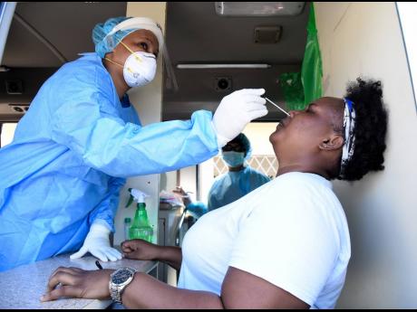 Dr Shanice Mullings swabs the nostrils of Kinolin Rose, a resident of Central Village, on January 13. The St Catherine Health Department was conducting free COVID-19 testing for residents.